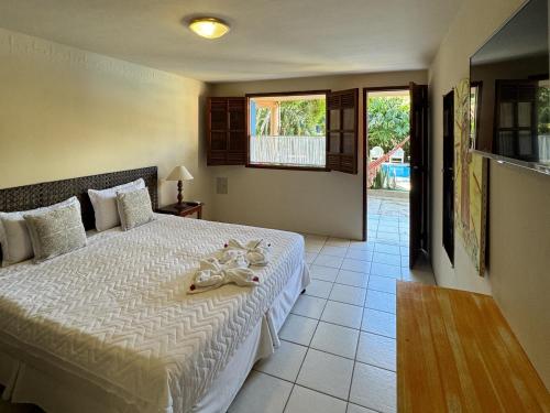a bedroom with a bed with towels on it at Pousada Bemvirá in Arraial d'Ajuda