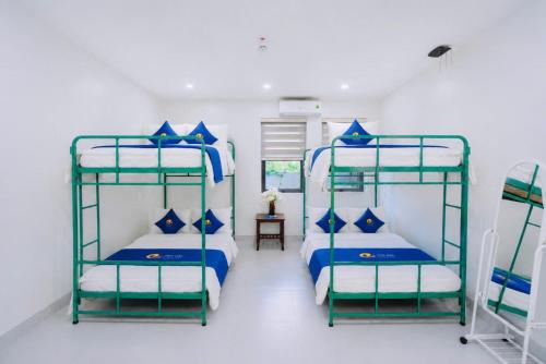 a bedroom with two bunk beds with blue pillows at Phu Hai Apartment in Dong Hoi