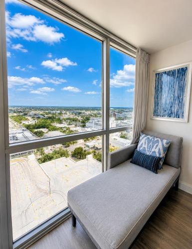 a couch in a room with a large window at Luxury Skyline Apartment- Resort-Style Pool , Gym & Game Room in Fort Myers