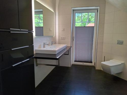 a bathroom with a sink and a toilet at Ferienhaus Strandnah - Ostseeurlaub in Glowe in Top-Lage in Glowe