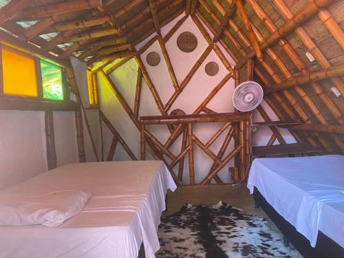 a bedroom with two beds in a wooden house at La aldea in Capurganá