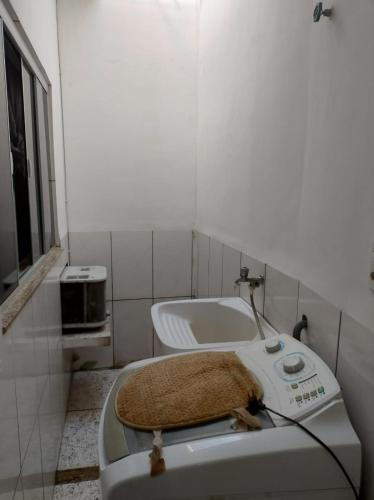 a small bathroom with a toilet with a rug on it at Casa no centro - perto de tudo in Itaguaí