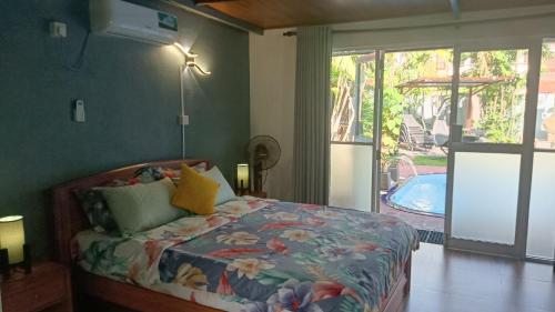 a bedroom with a bed and a swimming pool at Palms Villa in Negombo