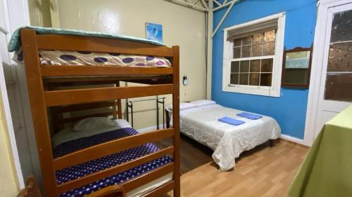 a bedroom with two bunk beds and a small bed at El Duke Kahanamoku surf hostel in Pacasmayo