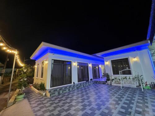 a house with blue lights on it at night at Hải Đảo Homestay in Quan Lạn