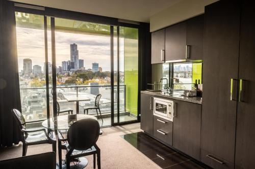 a kitchen with a table and a view of a city at Elli Prahran in Melbourne