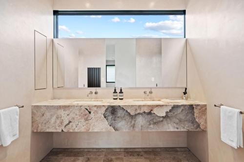 a bathroom with two sinks and a large mirror at Betula in Tilba Tilba