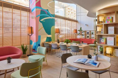 a restaurant with tables and chairs and a mural at INNSiDE by Meliá Barcelona Apolo in Barcelona