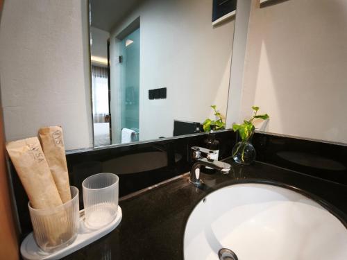 a bathroom with a sink and a mirror at Casa Mysa Hotel Kuta in Kuta
