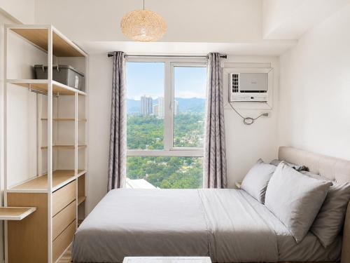 a bedroom with a bed and a window at Cozy Condo at Avida Tower 4, IT Park Cebu in Cebu City