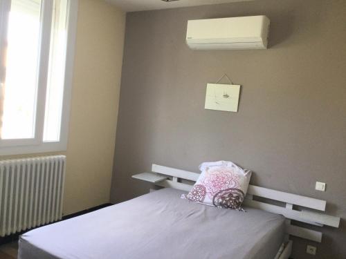a bedroom with a bed with a pillow and a window at Chez Lilly in Avignon