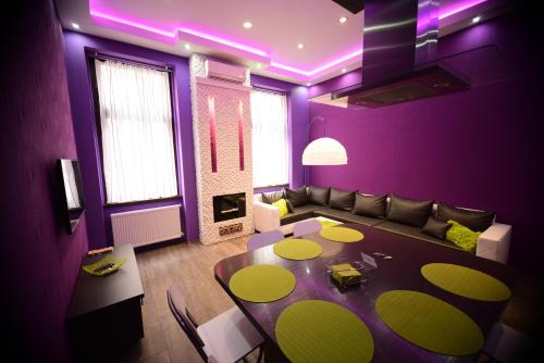uma sala de estar roxa com uma mesa e um sofá em Hernad Apartment em Budapeste