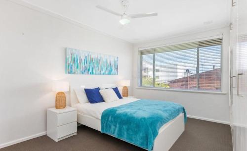 a white bedroom with a bed and a window at Ocean Views in Rockingham
