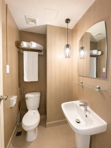 a bathroom with a toilet and a sink at MIGAs Haven at Sunvida Tower across SM City in Cebu City