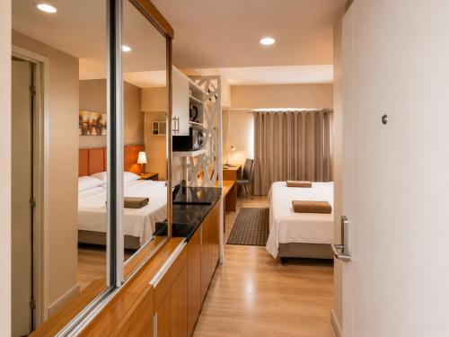 a hotel room with two beds and a mirror at MIGAs Haven at Sunvida Tower across SM City in Cebu City