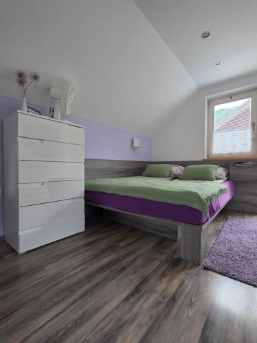 a bedroom with a bed and a dresser at Apartments & Chalet Jurček in Luče