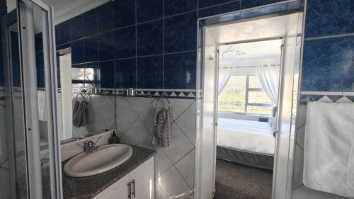 a bathroom with a sink and a mirror at Executive Sea View Apartment in Glencairn