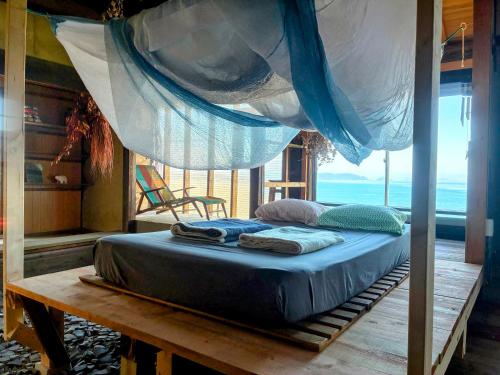 a bed in a room with a mosquito net at Lemon tree hotel in Higashiura