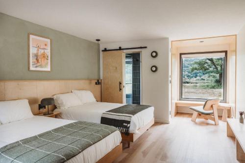a hotel room with two beds and a window at Otherland Hotel in Newfane
