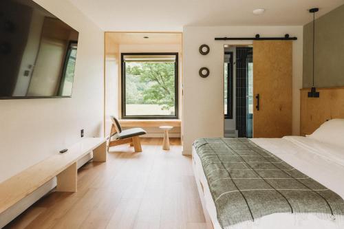 a bedroom with a bed and a window at Otherland Hotel in Newfane