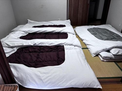 two unmade beds in a room with white sheets at base sanablend - Vacation STAY 39607v in Kyotango