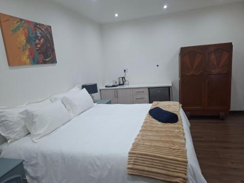 a bedroom with a white bed and a dresser at 47 Northward BnB in Newcastle