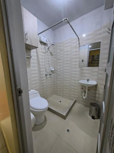 a white bathroom with a toilet and a sink at Esencia de Altura Hostal in El Tambo