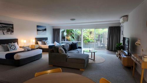 a large living room with a couch and a bed at Albacore Apartments in Merimbula