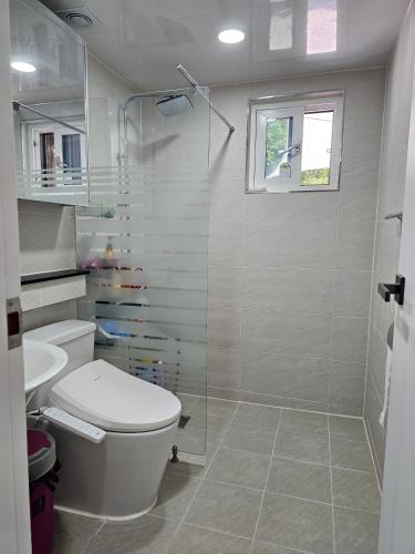 a white bathroom with a toilet and a shower at Twin Stay1 in Yonghwa