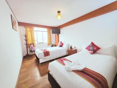 a hotel room with two beds with bows on them at Hotel Mirador All Sur in Cusco