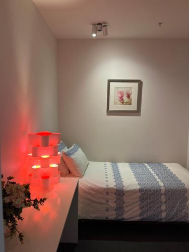 a bedroom with a bed with red lights on it at Camberwell Vacation Apartment in Melbourne