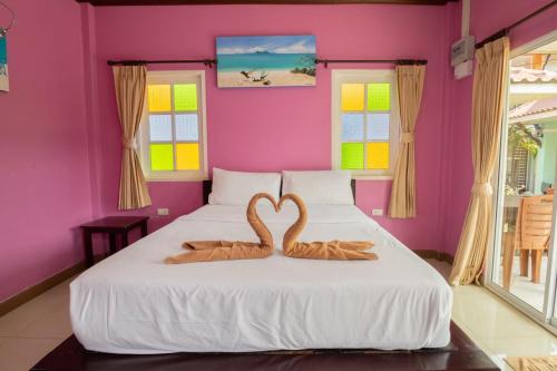 two swans in the shape of a heart on a bed at ไข่ปูพูลเกาะล้าน in Ko Larn