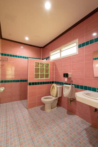 a pink bathroom with a toilet and a sink at ไข่ปูพูลเกาะล้าน in Ko Larn