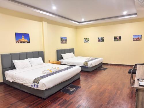a hotel room with two beds in a room at Yula Hotel in Vientiane