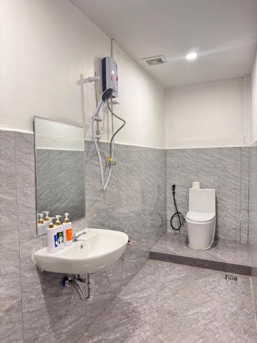 a bathroom with a sink and a mirror and a toilet at Yula Hotel in Vientiane
