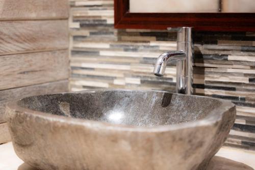 a sink with a faucet in a bathroom at La Gautch Bungalow in Nusa Lembongan