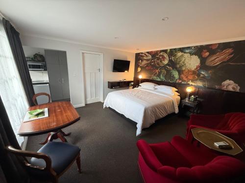 a hotel room with a bed and a table and chairs at Art Deco BNB in Havelock North