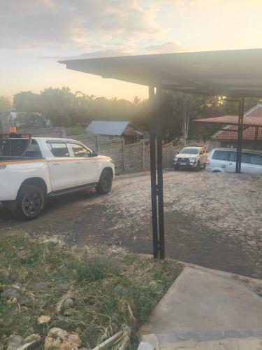 a white car parked in a gravel parking lot at Inara Homestay in Huu