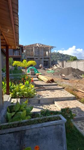 a garden with flowers and a building in the background at Inara Homestay in Huu