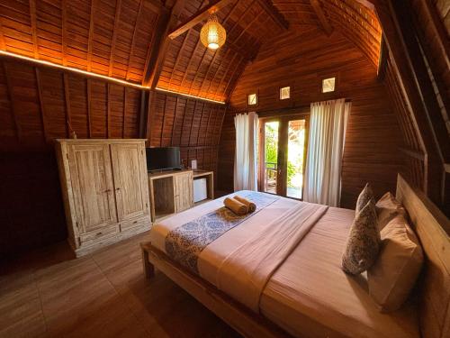 a bedroom with a large bed in a wooden room at Druwa Bali in Uluwatu