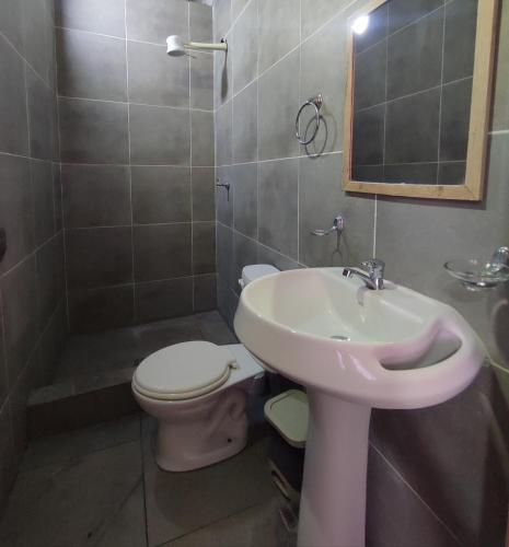 a bathroom with a sink and a toilet and a mirror at Hospedaje Hotel Chone in Chone