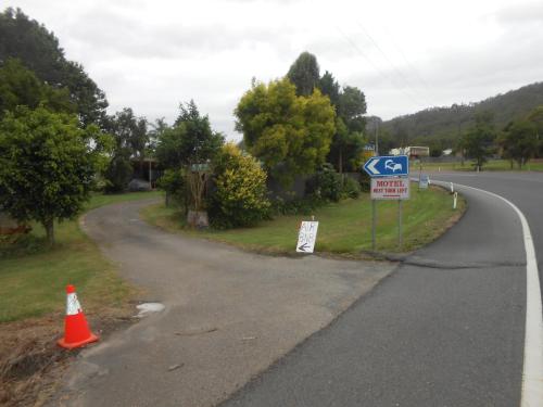 a winding road with a street sign and a traffic cone at Mount View Motel in Bulahdelah