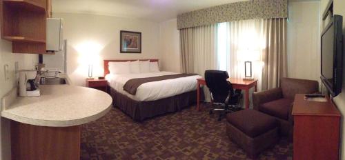 Habitación de hotel con cama, escritorio y silla en Alaska's Select Inn Wasilla, en Wasilla