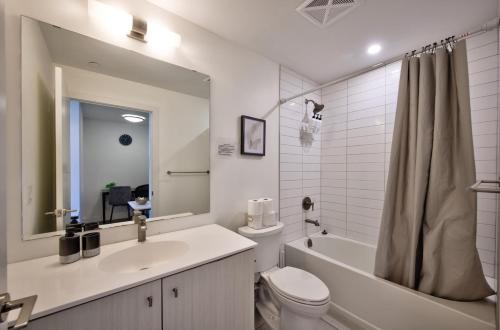 a bathroom with a sink and a toilet and a tub at Cozy Condo in Downtown KW in Kitchener