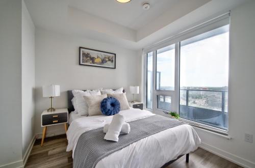 a bedroom with a large bed and a large window at Cozy Condo in Downtown KW in Kitchener