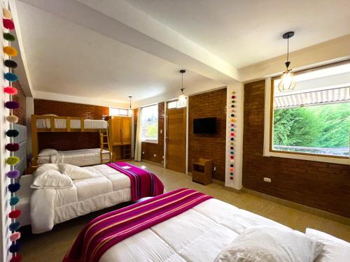 a bedroom with two beds and a flat screen tv at Runaway Hotel in Carhuaz