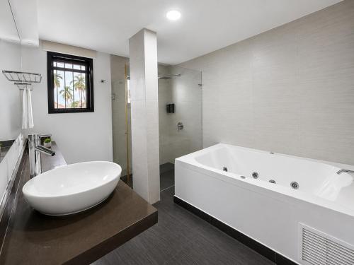a white bathroom with a large tub and a sink at Hotel Habitat San Antonio in Cali