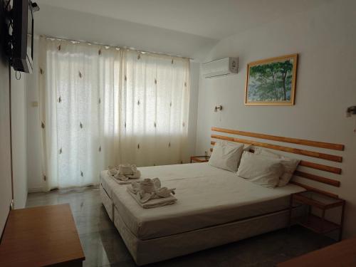 a bedroom with a bed with two teddy bears on it at Hotel Lozite in Sozopol