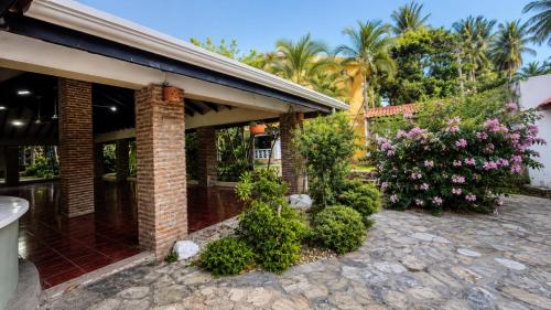 a brick house with bushes and flowers at Costa lisa in Cabarete
