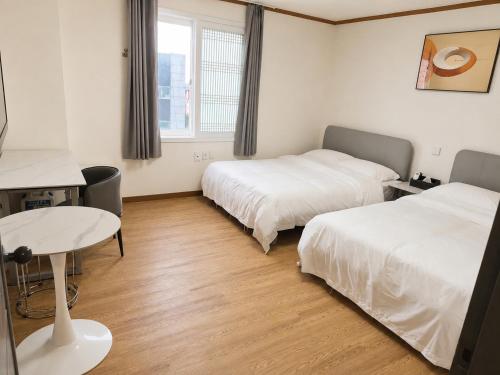 a hotel room with two beds and a table at New Star Hotel in Chu-sung